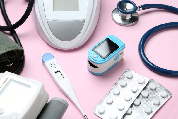 Digital pressure meter and medical objects on color background - Zdjęcie, obraz