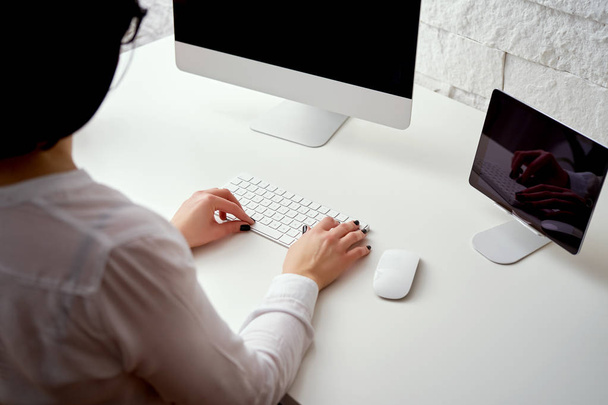オフィスで仕事をしているホワイトのキーボードで入力して、コンピューターを使用して女性の手のクローズ アップ - 写真・画像