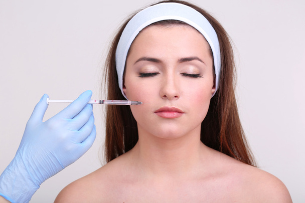 Young woman receiving plastic surgery injection on her face close up - Fotoğraf, Görsel