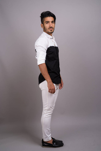Joven hombre de negocios persa guapo contra fondo gris
 - Foto, imagen