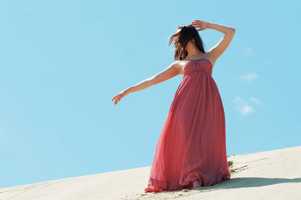 Vrouw in rode jurk met vliegende weefsel, Beautiful girl spinning zwaaien - Foto, afbeelding