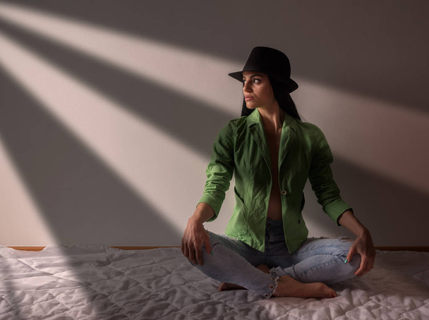 Girl with a hat and an open jacket sitting on the floor - Photo, image