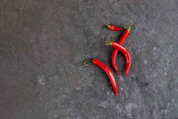 Red chilli peppers on concrete background - Foto, imagen