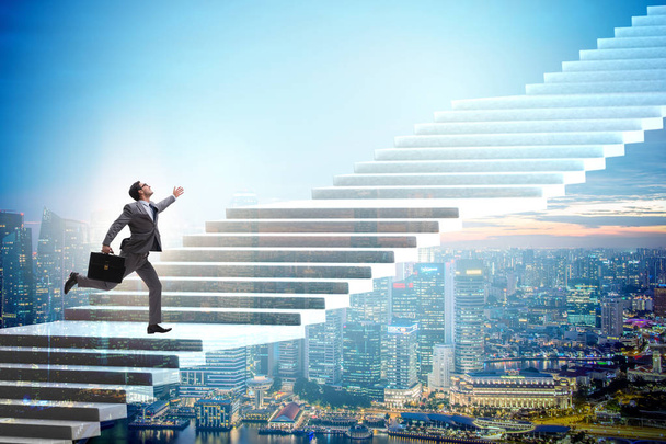 Бизнесмен поднимается по карьерной лестнице над городом
 - Фото, изображение