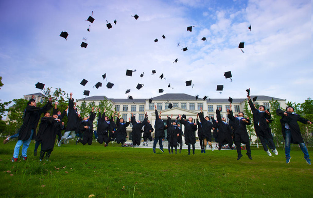 研究用のガウンを着た中国人卒業生は、東中国浙江省舟山市の浙江海洋大学での写真撮影セッション中に卒業を祝うために空気中に帽子を投げる, 15 5 月2015. - 写真・画像