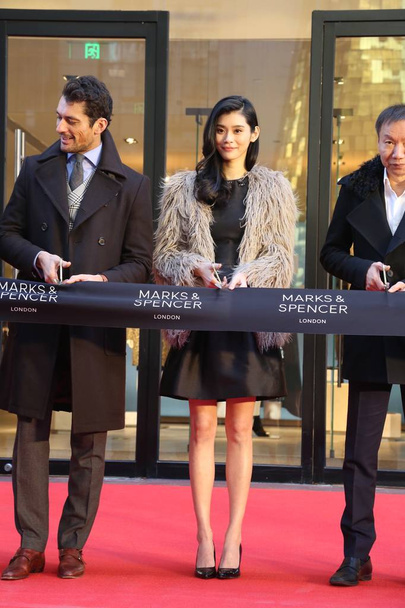 Chinese model Ming Xi, center, also known as Xi Mengyao, and English model David Gandy, left, cut the ribbon at an opening event of the flagship store of Marks & Spencer in Beijing, China, 18 December 2015. - Фото, зображення