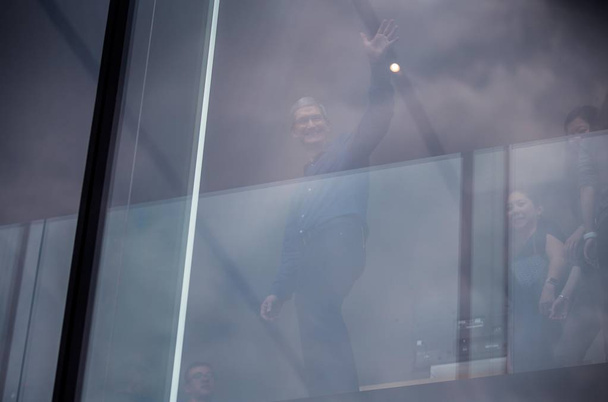 Tim Cook, CEO of Apple Inc., waves to passers-by as he visits the Apple Store near the West Lake in Hangzhou city, east China's Zhejiang province, 24 October 2015. - Photo, Image