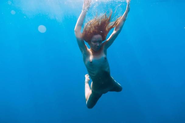 Γυμνή γυναίκα βουτιά στην θάλασσα, υποβρύχιο στον τροπικό ωκεανό - Φωτογραφία, εικόνα