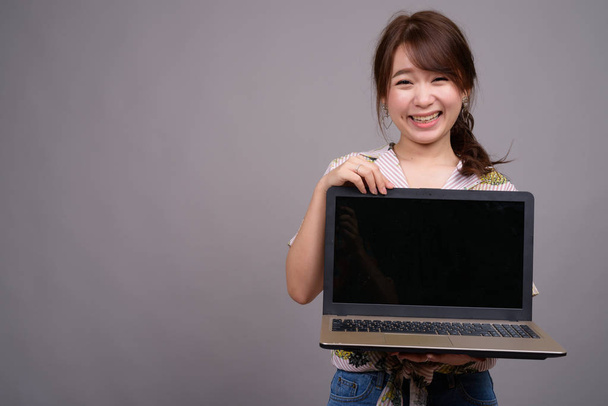 Молодая красивая азиатская туристка с ноутбуком
 - Фото, изображение