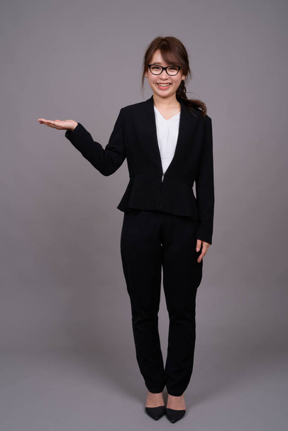 Retrato de comprimento total de jovem empresária asiática de pé
 - Foto, Imagem