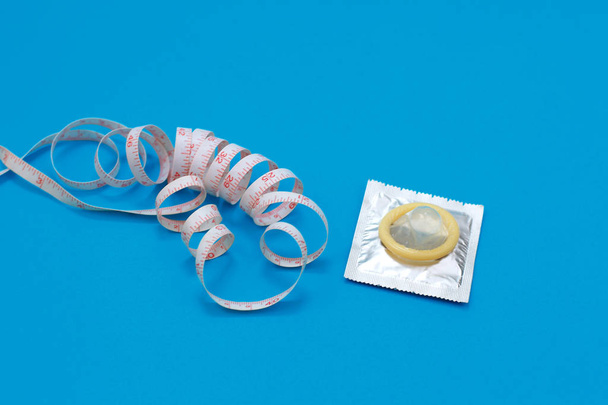Condón y cinta métrica en forma de pene. Cómo elegir el tamaño de condón adecuado
 - Foto, imagen