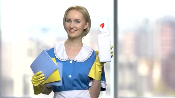 Pretty smiling chambermaid holding cleaning supplies. - Footage, Video