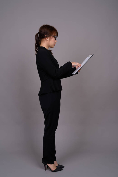立っている若いアジア女性実業家の完全な長さの肖像画 - 写真・画像