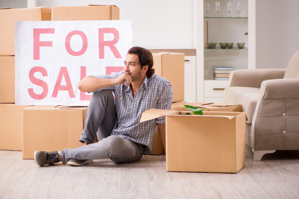 Jonge man home te koop aanbieden en verhuizen  - Foto, afbeelding