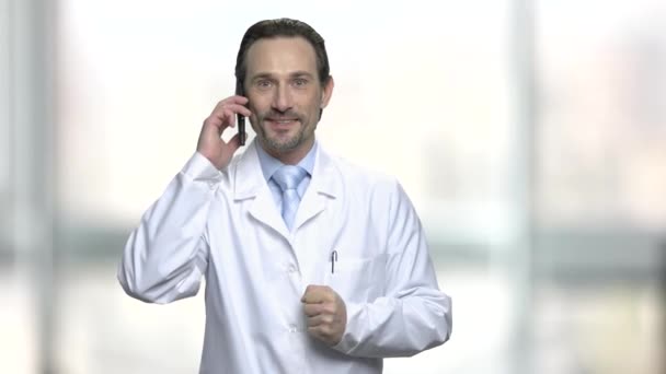 Satisfied male doctor talking on phone. - Séquence, vidéo