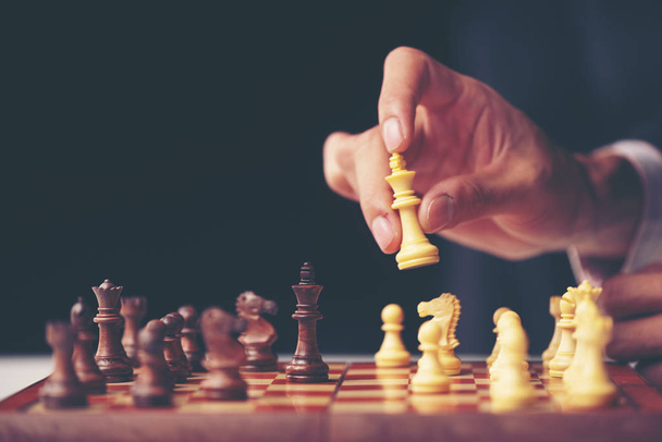 hand of businessman moving chess figure in competition success play. strategy, management or leadership concept - Foto, Imagen