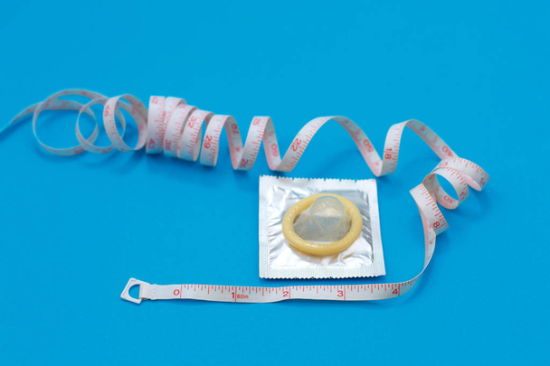 Kondom und Maßband in Form eines Penis. So wählen Sie die richtige Kondomgröße - Foto, Bild