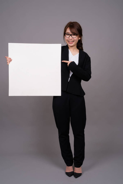 Full length portrait of young Asian businesswoman standing - Foto, imagen
