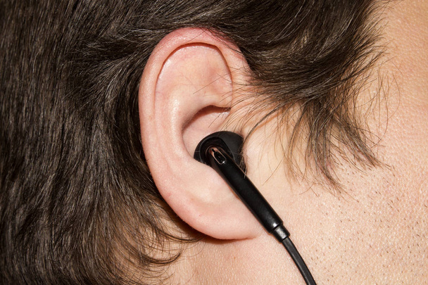 Earpiece in the human ear.Headset for communication in the human ear. - Photo, Image