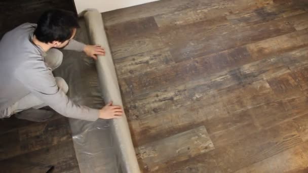 ο άνθρωπος, προστατεύοντας το πάτωμα με πλαστικό φύλλο  - Πλάνα, βίντεο