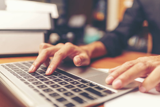 Обрезанный снимок рук человека с помощью ноутбука дома, вид сзади на руки бизнесмена, занятого ноутбуком на рабочем столе, молодой студент-мужчина, печатающий на компьютере, сидящий за деревянным столом
 - Фото, изображение