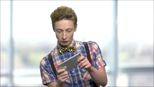 Expresivní dospívající chlap hrát hru na telefonu. - Záběry, video