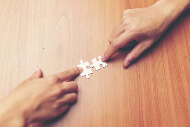 Uomo mani collegamento pezzo puzzle coppia in ufficio. Soluzioni aziendali, target, successo, obiettivi e concetti strategici
 - Foto, immagini