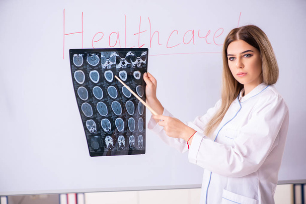 Jovem médica em pé na frente do quadro branco
  - Foto, Imagem