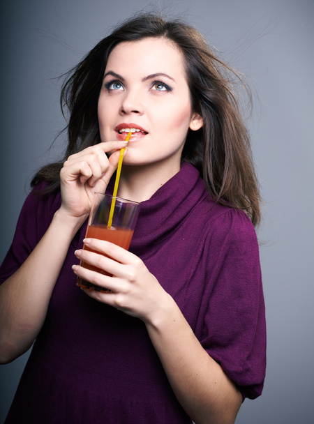 Attractive young woman in a dress. Woman drinking juice and look - Foto, Bild