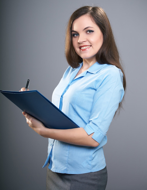 aantrekkelijke jonge vrouw in een blauw shirt. vrouw houdt een blauwe folde - Foto, afbeelding