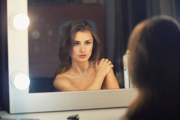 Beautiful sexy woman looking into a mirror - Foto, imagen