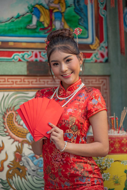 Asian girl in red dress standing in holy place on Chinese New Year. - Photo, Image