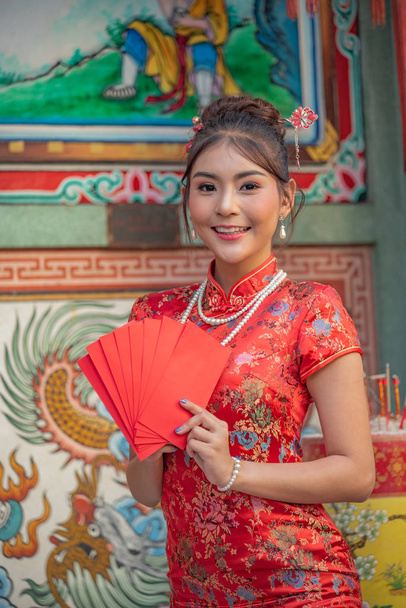asiático chica en rojo vestido de pie en santo lugar en china nuevo año
. - Foto, imagen