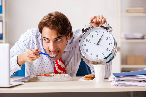 Ο άνθρωπος που έχοντας το γεύμα στην εργασία κατά τη διάρκεια διαλείμματος - Φωτογραφία, εικόνα
