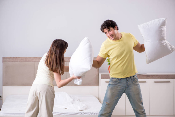 Żona i mąż mając poduszkę walki w sypialni - Zdjęcie, obraz