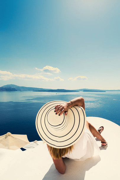 Luxury travel vacation woman looking at view on Santorini island in Greece. Amazing view of sea and Caldera. - Фото, изображение