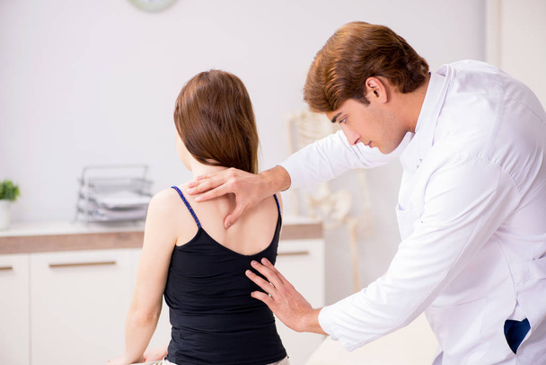 Vrouwelijke patiënt op bezoek bij jonge knappe arts chiropractor  - Foto, afbeelding