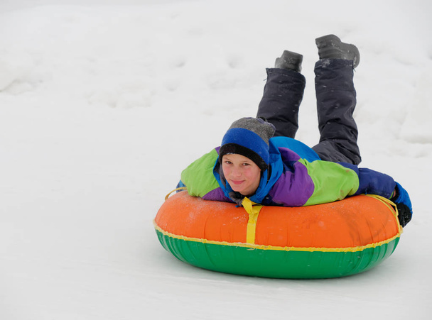 人々 は雪のスライドをチューブに乗って楽しい時を過す - 写真・画像