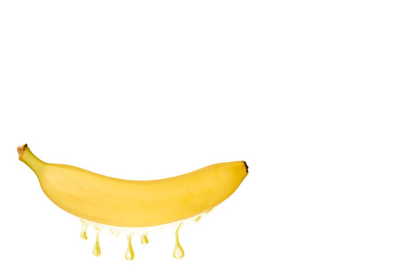 Ripe banana fruit with a juice dropping from it, isolated on white background, copy space template - Foto, afbeelding