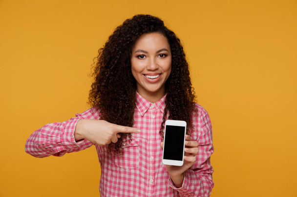 Photo de joyeux mignon belle jeune femme bavarder par téléphone mobile isolé sur fond de mur jaune
. - Photo, image