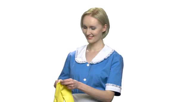 Νεαρή καμαριέρα χαμογελώντας βάζει σε κίτρινα γάντια. - Πλάνα, βίντεο