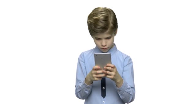 Χαριτωμένο αγόρι με smartphone σε λευκό φόντο. - Πλάνα, βίντεο