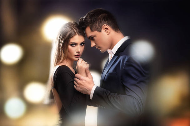 Young beautiful couple posing together in elegant clothes. - 写真・画像