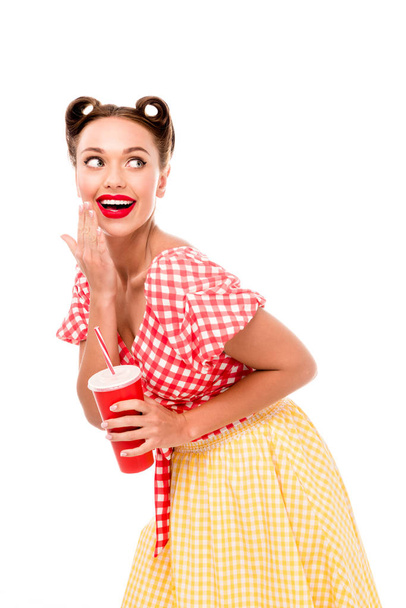 Young smiling pin up girl holding red paper cup with straw isolated on white - Foto, immagini