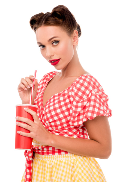 Pretty smiling pin up girl holding disposable cup and looking at camera isolated on white - Foto, Imagem