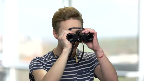 Curious teenage boy looking through binoculars. - Footage, Video