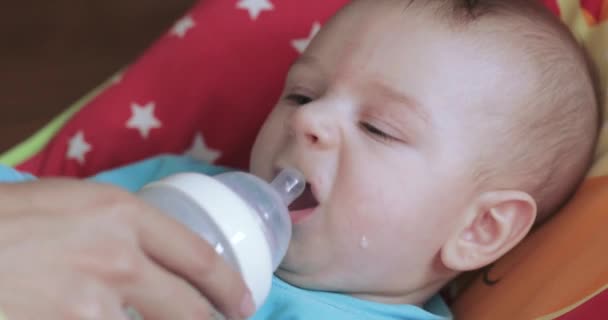 Child learns to drink from a bottle - Video