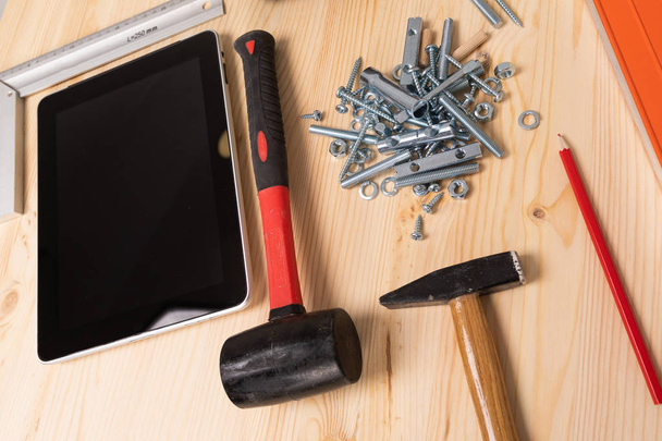 Stavební nástroj a digitální tablet leží na lehký dřevěný stůl - Fotografie, Obrázek