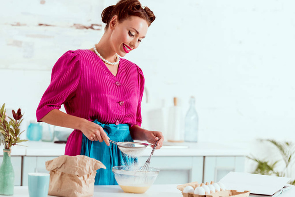 smiling elegant pin up girl mixing ingredients for dough - Foto, Imagem