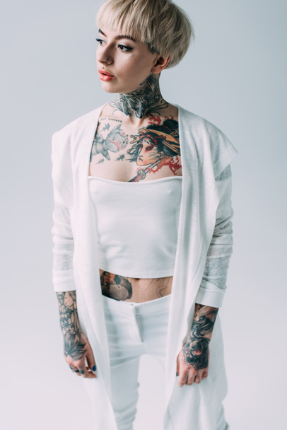 attractive woman with tattoos standing isolated on grey - Foto, Imagen